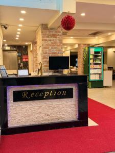 a reception desk in a store with a red carpet at Holiday Hotel in Erdemli