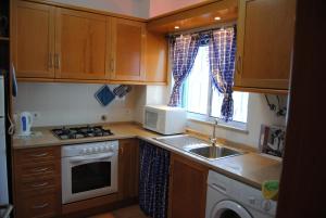 a small kitchen with a sink and a microwave at Vilamoura Apartment in Vilamoura