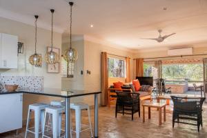 a kitchen and living room with a table and chairs at Kruger's Retreat & Rest in Marloth Park +23 photos