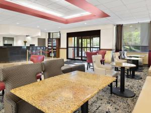 a waiting area with tables and chairs in a room at Best Western Potomac Mills in Woodbridge