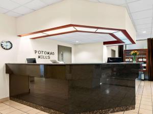 a reception desk in a lobby with a clock at Best Western Potomac Mills in Woodbridge +37 photos