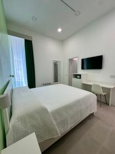 a bedroom with a bed and a desk and a television at I Colori della Bellezza in Gragnano