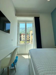 a bedroom with a bed and a desk and a window at I Colori della Bellezza in Gragnano