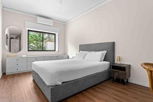 a bedroom with a large bed and a window at Estoril Riviera Residences in Estoril +16 photos