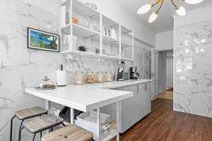 a white kitchen with a counter and stools at Estoril Riviera Residences in Estoril