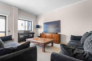a living room with two couches and a flat screen tv at Estoril Riviera Residences in Estoril
