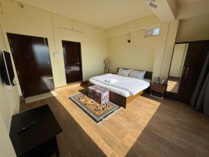 a small bedroom with a bed and a mirror at The Khaar in Tawang