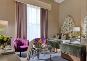 a hotel room with two beds and purple chairs at Ariel House in Dublin