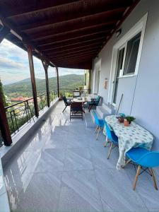 a patio with tables and chairs on a balcony at AnnaPolys House in Kavála