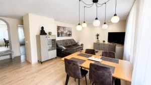 a dining room and living room with a table and chairs at Apartamentai Tarp 7 Ežerų in Zarasai