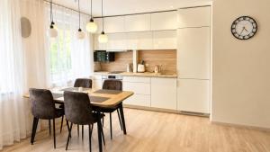 a kitchen and dining room with a table and chairs at Apartamentai Tarp 7 Ežerų in Zarasai
