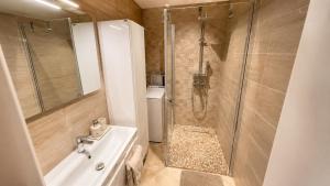 a bathroom with a shower and a sink and a toilet at Apartamentai Tarp 7 Ežerų in Zarasai +2 photos