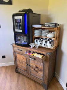 a microwave oven sitting on top of a wooden cabinet at Hôtel L'escale des Hayons in Esclavelles