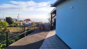 a white house with a blue door and a fence at Casa de Campo Serrão in Calheta +11 photos