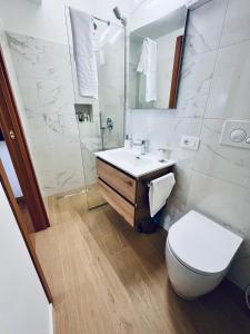 a white bathroom with a toilet and a sink at Casa Araiani in Ariano Irpino