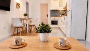 two coffee mugs sitting on a wooden table in a kitchen at La Maya in Caleta De Fuste