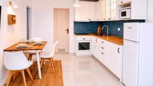 a kitchen with a wooden table and white appliances at La Maya in Caleta De Fuste