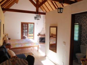 ein Schlafzimmer mit einem Bett und einem Spiegel in einem Zimmer in der Unterkunft Pousada São Luiz - Monte Verde in Monte Verde