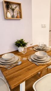 a wooden table with plates and wine glasses on it at La Maya in Caleta De Fuste +26 photos