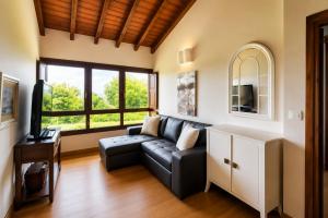 a living room with a couch and a tv at Villa Los Bufones de Pria in Llames de Pría