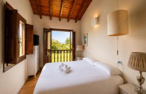 a bedroom with a large white bed with a window at Villa Los Bufones de Pria in Llames de Pría +26 photos