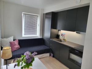 a small kitchen with a couch and a sink at Studio Sleeps 2 Sollentuna centre in Sollentuna