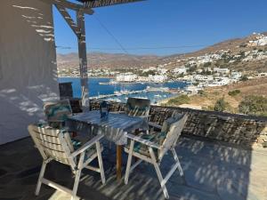 a table and chairs on a patio with a view of the water at Artistic Villa Aqua Ios in Ios Chora