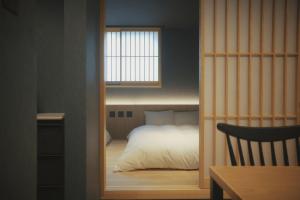 a small bedroom with a bed and a window at Amu in Beppu