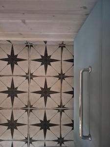 a bathroom with a tile floor with stars on it at Pine House Domek 22 in Borsk