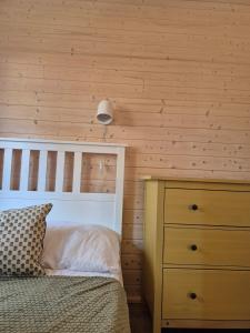 a bedroom with a bed and a wooden wall at Pine House Domek 22 in Borsk