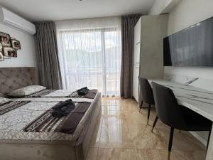 a bedroom with two beds and a desk and a large window at VP Onyx Apartment in Elenite