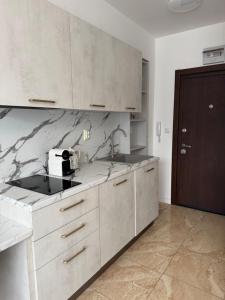 a kitchen with white cabinets and marble counter tops at VP Onyx Apartment in Elenite