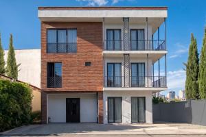 a brick house with a balcony on a street at M&N Hotel in Tbilisi City