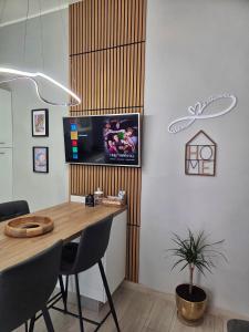 a dining room with a table and a tv on the wall at Cà Fiamma 1 in Casale Monferrato