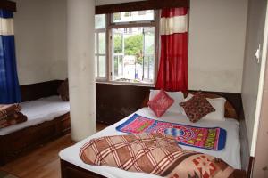 a bedroom with two beds and a window at Hotel reegyal in Ravangla