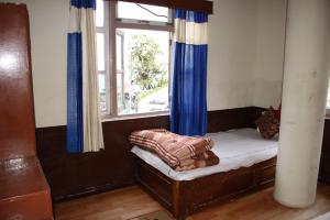a small bed in a room with a window at Hotel reegyal in Ravangla +18 photos