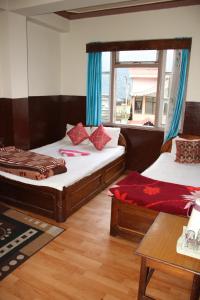 a bedroom with two beds and a window at Hotel reegyal in Ravangla