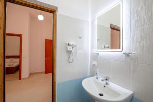 a bathroom with a sink and a mirror at Center Apartments in Ksamil +32 photos
