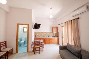 a living room with a couch and a kitchen at Center Apartments in Ksamil