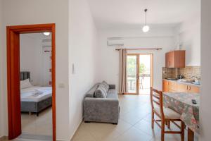 a kitchen and a living room with a couch and a table at Center Apartments in Ksamil