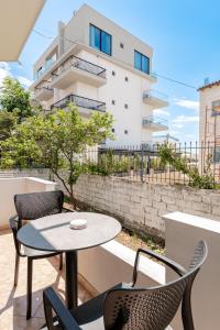 a patio with chairs and a table and a building at Center Apartments in Ksamil