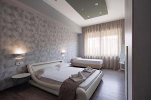 a bedroom with a large white bed and a sink at La Palazzata Urban Suites in Messina