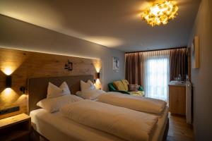 a bedroom with two beds and a chandelier at Hotel Hochfilzer in Ellmau