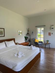a bedroom with a large bed with white sheets at Stayokay Sattahip ที่พักสัตหีบ in Sattahip +171 photos