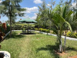 a park with a table and an umbrella in the grass at Chakruok Gardens, Hawi in Bondo