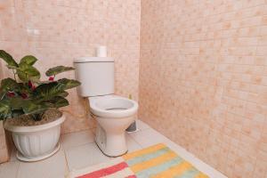 a bathroom with a toilet and a potted plant at Chakruok Gardens, Hawi in Bondo +13 photos