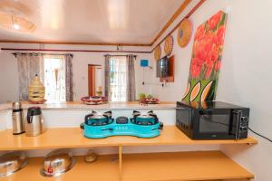 a kitchen with a stove and a microwave on a shelf at Chakruok Gardens, Hawi in Bondo