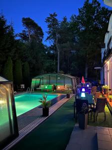 a backyard with a swimming pool at night at Pensjonat Perła in Pobierowo