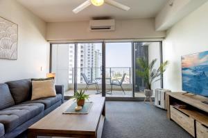 a living room with a couch and a table at Harbour View Apartment on 11th floor King Bed in Darwin