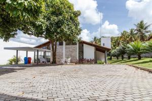 a house with a brick driveway in front of it at Hotel SESI PB - Parque da Mata in Rio Tinto
